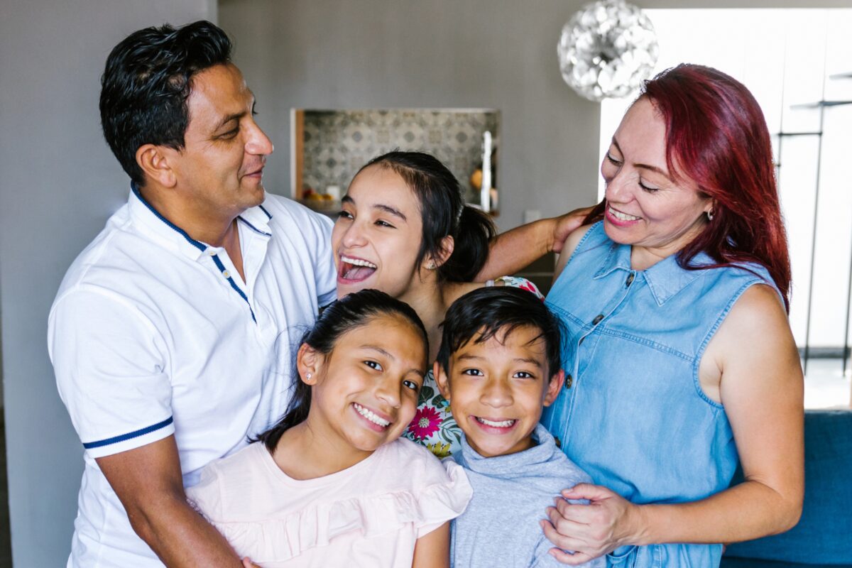 A family of five laughing together at home