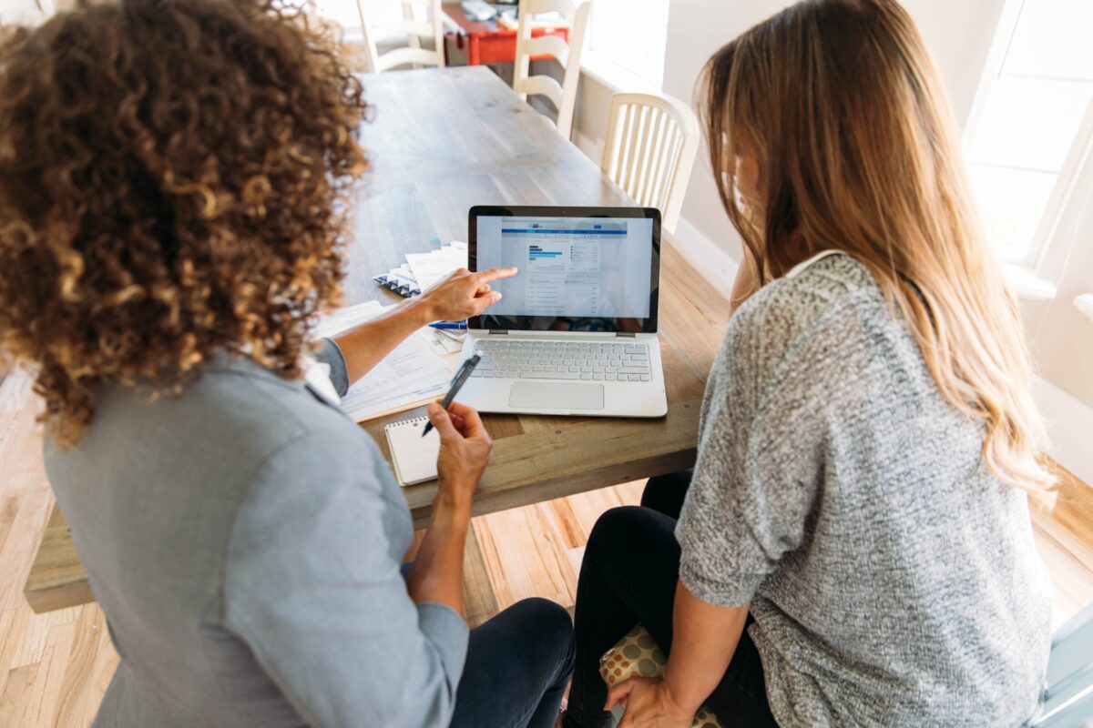 An advocate pointing out resources on a laptop while meeting with a community member